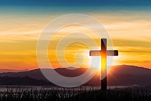 Silhouette of cross on mountain sunrise background