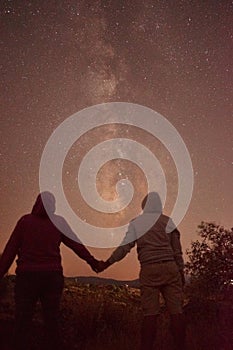 Silhouette of cross at night with beautiful milky way backgroundSilhouette of a man and a woman in love holding hands with beautif