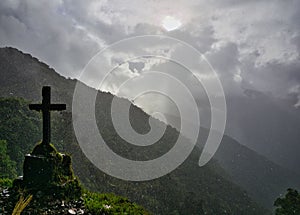 Silhouette of a cross / tomb stone on a rainy day on the Death Road in the Yungas, Bolivia