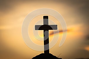Silhouette of crucifix cross at sunset time with holy and light background