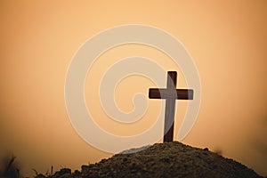 Silhouette of crucifix cross at sunset time with holy and light background