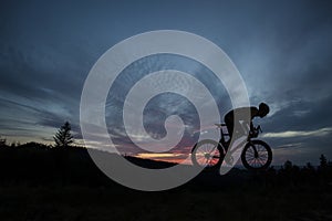 The silhouette of the cyclist on bike at sunset.A man ride on bike on the mountains. Sport and active life concept sunset time. A
