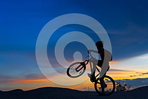 Silhouette of cyclist in motion on the background of beautiful sunset