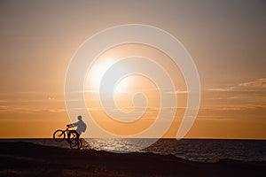 Silhouette of cyclist in motion at beautiful sunset