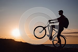 Silhouette of cyclist in motion at beautiful sunset