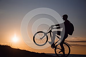 Silhouette of cyclist in motion at beautiful sunset