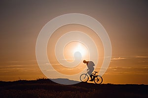 Silhouette of cyclist in motion at beautiful sunset