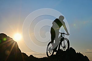 Silhouette Of A Cyclist Standing on Clif Against The Sun