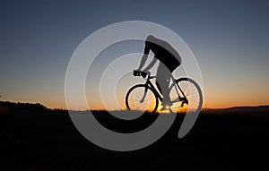 Silhouette of cyclist in sunset photo