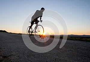 Silhouette of cyclist in sunset