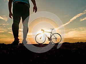 Silhouette of cyclists with bicycles at sunset