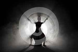 Silhouette dancer performing dance figures.