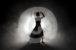 Silhouette dancer performing dance figures.