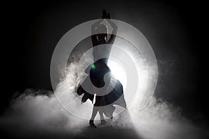 Silhouette dancer performing dance figures.