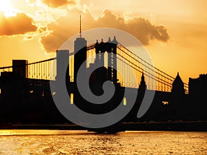 Silhouette of the downtown Manhattan skyline and the Manhattan Bridge at sunset