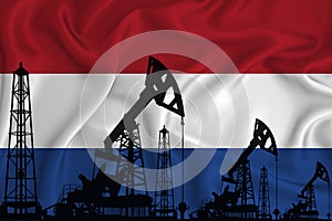 Silhouette of drilling rigs and oil derricks on the background of the flag of Netherlands. Oil and gas industry. The concept of