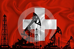 Silhouette of drilling rigs and oil derricks on the background of the flag of Switzerland. Oil and gas industry. The concept of