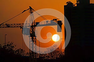 Silhouette dusk construction site of crane over sunset background