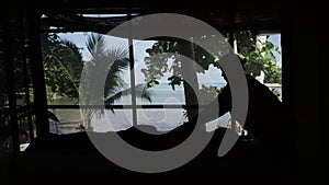 Silhouette of elder Thai woman performing massage on customer at spa next to the beach