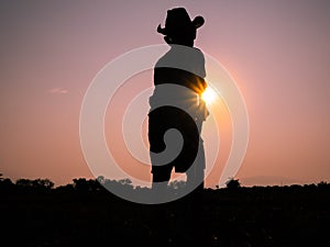 Silhouette of Elderly Asian farmers shoveling and prepare the soil with a spade for planting on sunset background