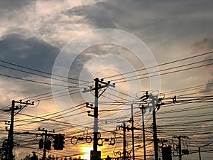 Silhouette electric poles and tangled wires cable on sunset