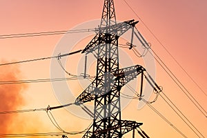 Silhouette of electrical transmission towers. High voltage tower shadow on orange color sunset.