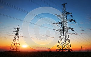 Silhouette of electricity pylons and high-voltage power lines on