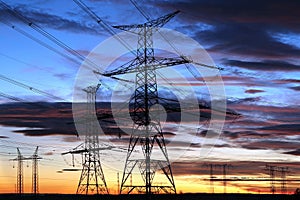 Silhouette of electricity pylons during sunset