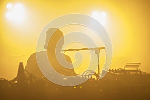 A silhouette of electronic musician during live concert in yellow light.