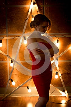 Silhouette of elegant woman in dress posing against big glowing