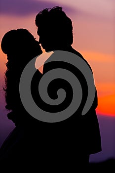 Silhouette of Embracing Asian Bride and Groom at Sunset