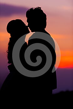 Silhouette of Embracing Asian Bride and Groom at Sunset