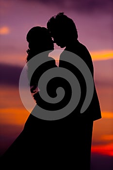 Silhouette of Embracing Asian Bride and Groom at Sunset