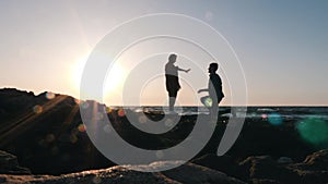 Silhouette of enamored young man making proposal to his beloved girlfriend. Enamored man kneeling down and making marriage proposa