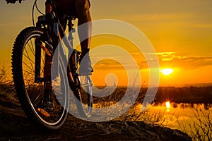 Silhouette of Enduro Cyclist Riding the Mountain Bike on the Rocky Trail at Sunset. Active Lifestyle Concept. Space for Text.