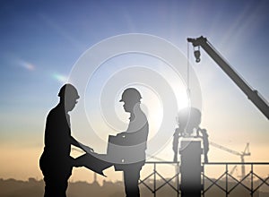 Silhouette engineer looking work a building site over Blurred co