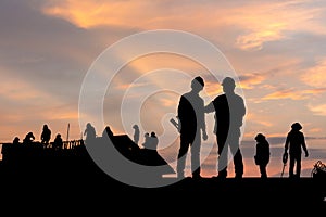 Silhouette of Engineer and worker on building site, construction site at sunset in evening time