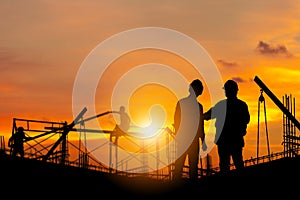 Silhouette of Engineer and worker with clipping path on building site, construction site at sunset in evening time