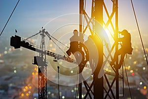 Silhouette of Engineer and worker working crane on steel structures industrial project at building site background, construction