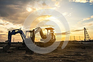 Silhouette of excavator in construction site during sky sunset
