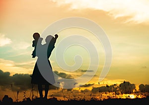 Silhouette of a family comprising a father, mother and two children happy family the sunset.Concept of friendly