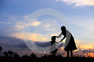 Silhouette of a family comprising a father, mother and two children happy family the sunset.Concept of friendly