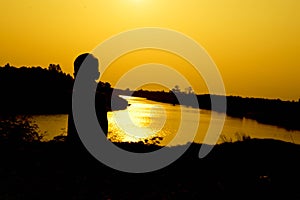 Silhouette of a family comprising a father, mother and two children happy family the sunset.Concept of friendly