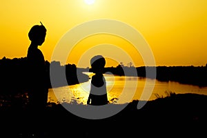 Silhouette of a family comprising a father, mother and two children happy family the sunset.Concept of friendly