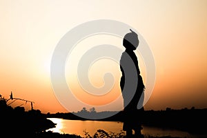 Silhouette of a family comprising a father, mother and two children happy family the sunset.Concept of friendly