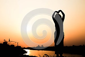 Silhouette of a family comprising a father, mother and two children happy family the sunset.Concept of friendly