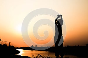 Silhouette of a family comprising a father, mother and two children happy family the sunset.Concept of friendly