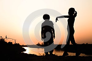 Silhouette of a family comprising a father, mother and two children happy family the sunset.Concept of friendly