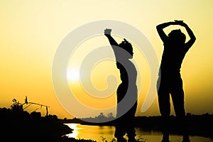 Silhouette of a family comprising a father, mother and two children happy family the sunset.Concept of friendly