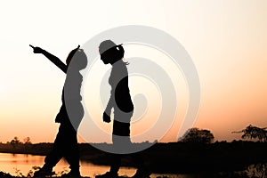 Silhouette of a family comprising a father, mother and two children happy family the sunset.Concept of friendly